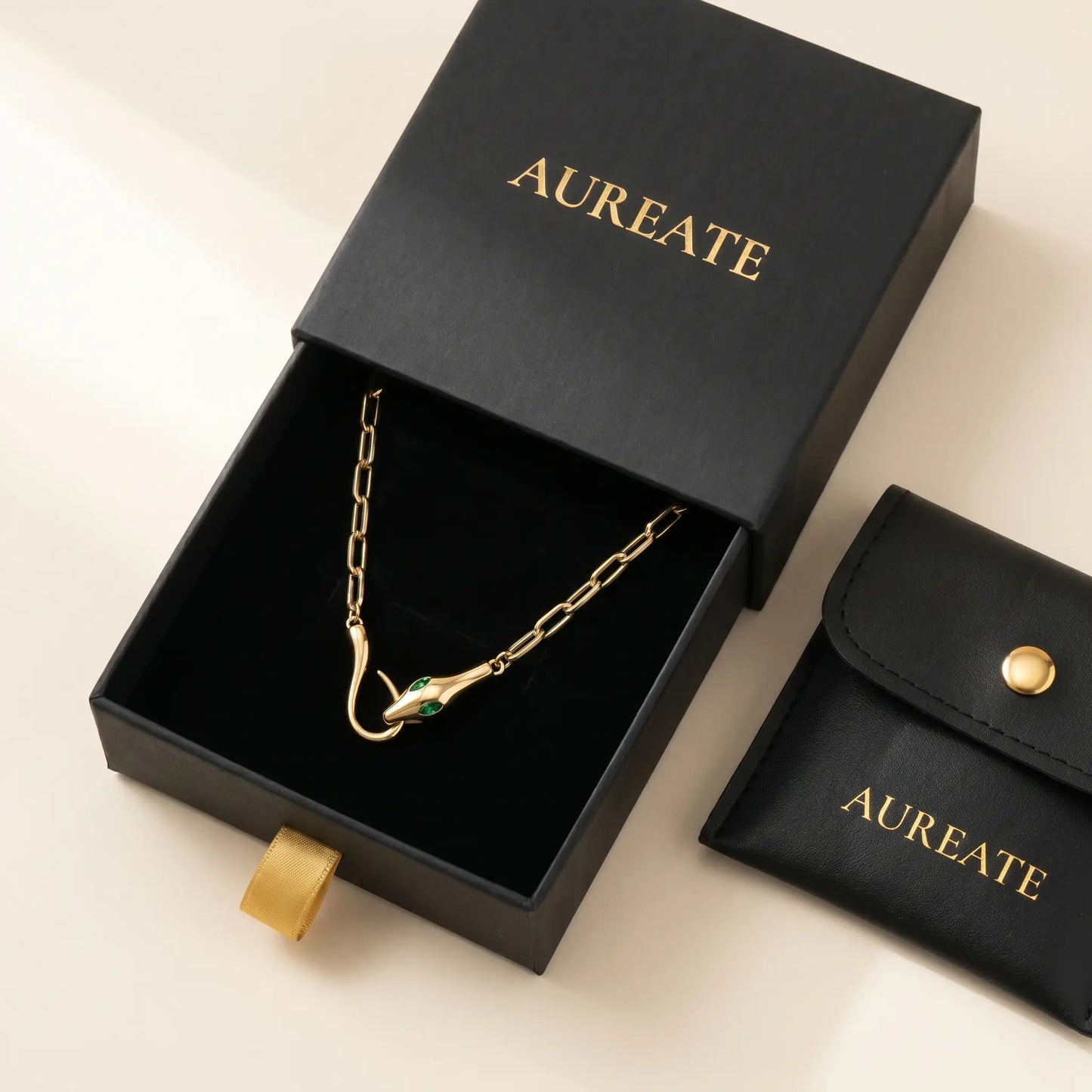 AUREATE Snake Pendant Necklace gift box - matte black slide-drawer gold serif logo with leather pouch and emerald CZ eyes visible