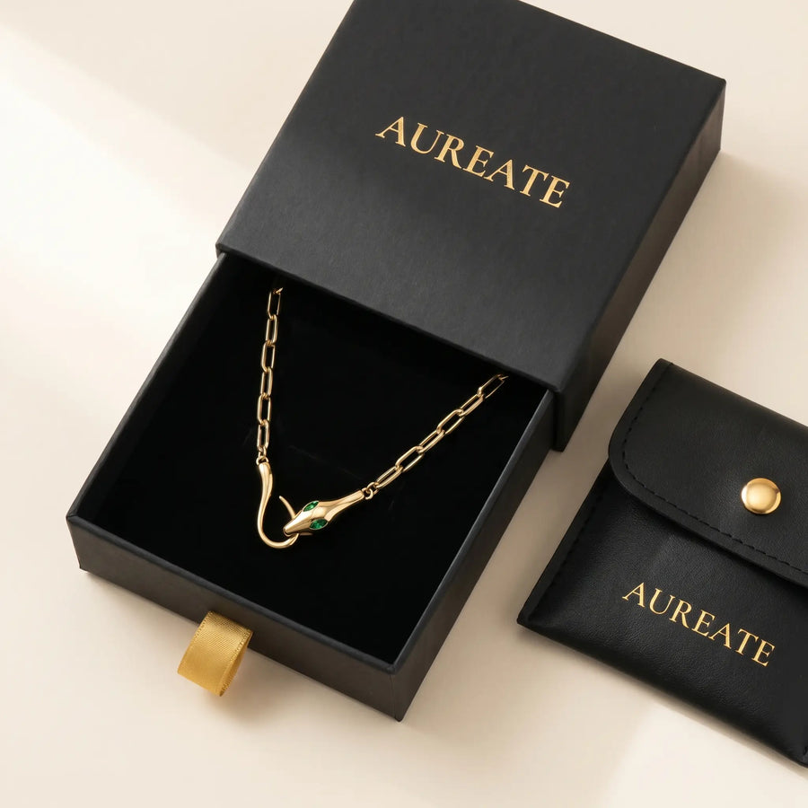 AUREATE Snake Pendant Necklace gift box - matte black slide-drawer gold serif logo with leather pouch and emerald CZ eyes visible