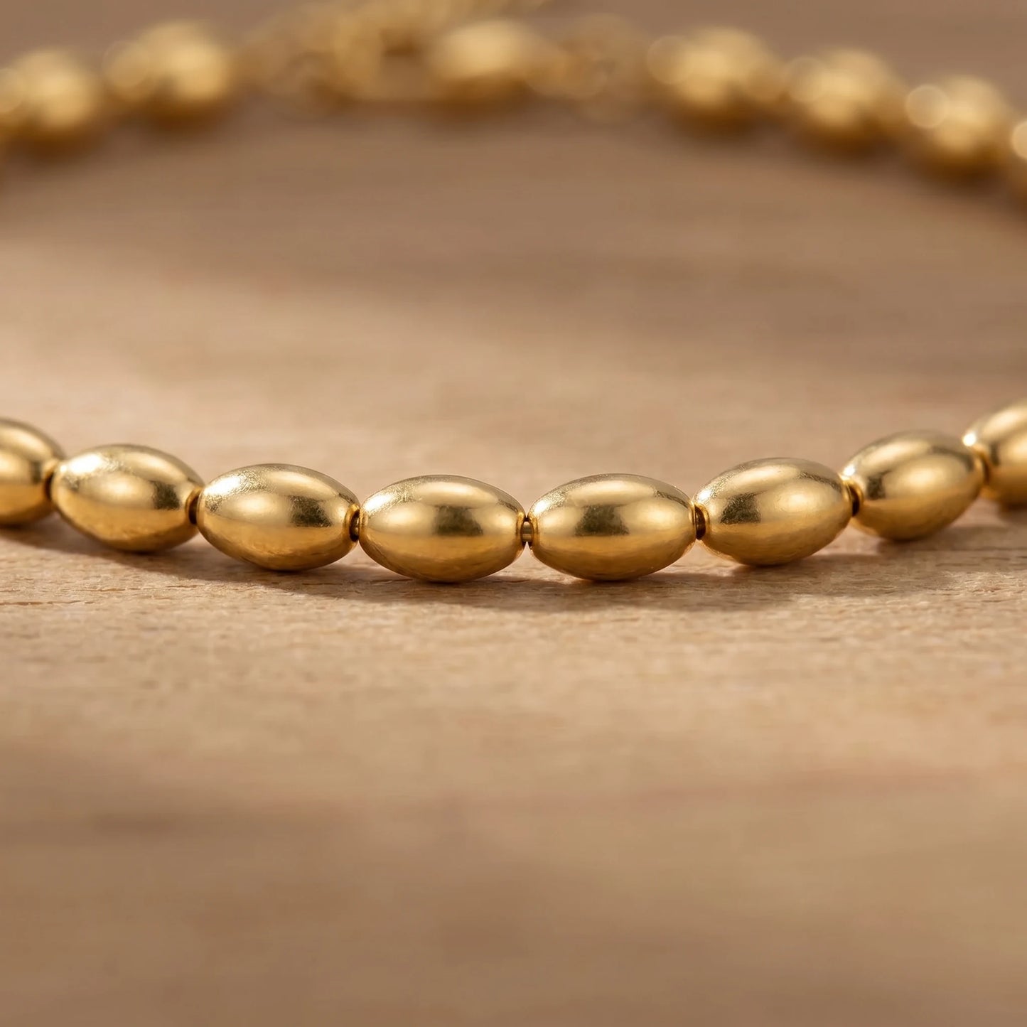Gold oval bead anklet macro detail of olive beads
