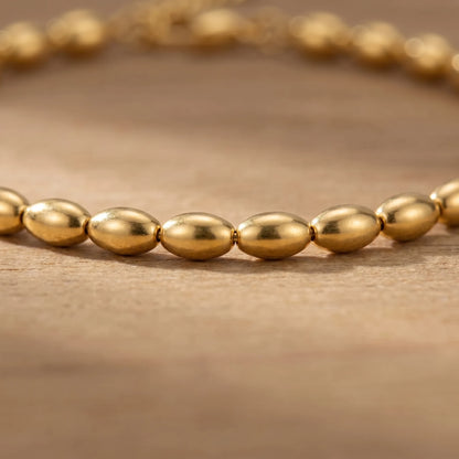 Gold oval bead anklet macro detail of olive beads