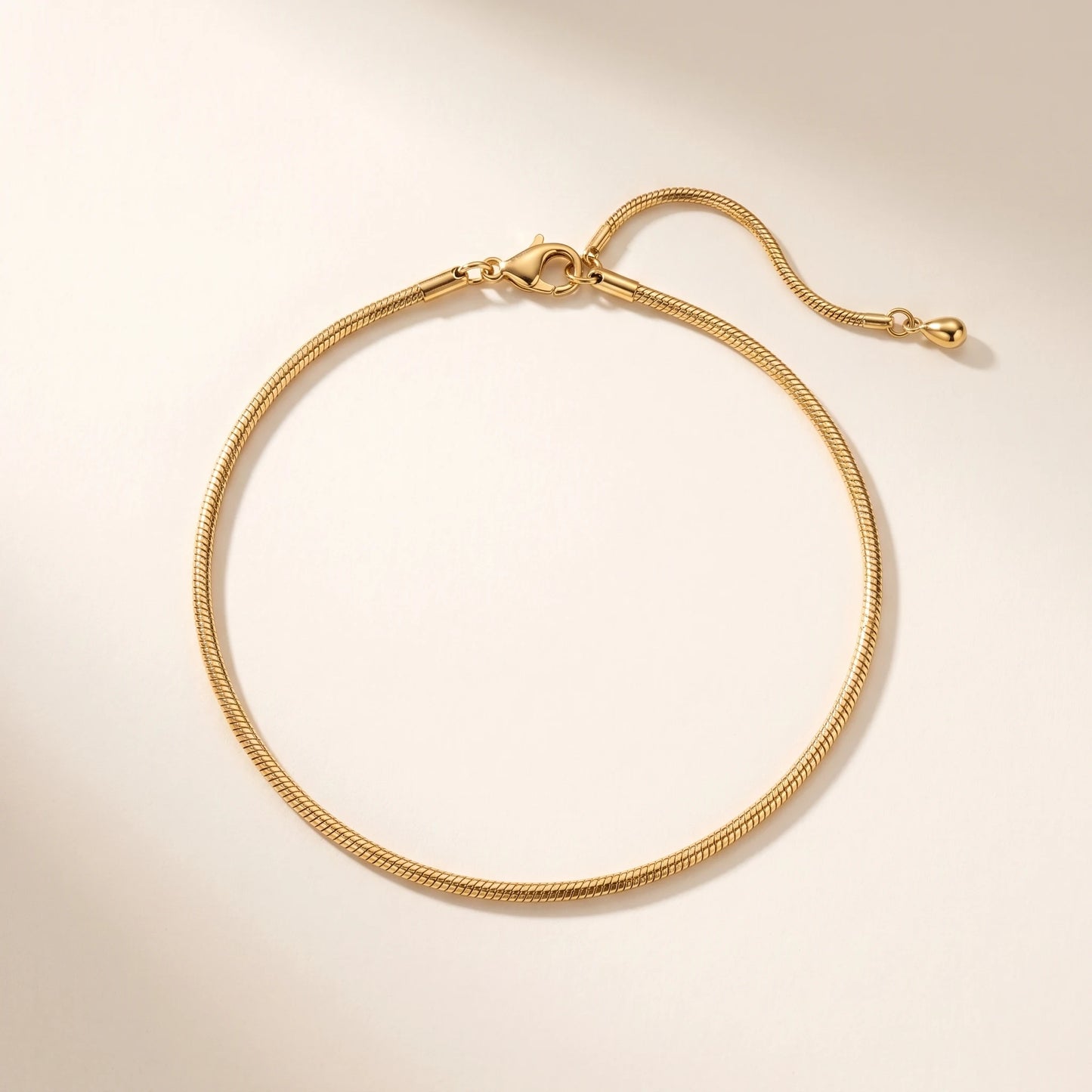 Dainty gold snake chain anklet packshot off-white clean symmetric oval composition extension teardrop