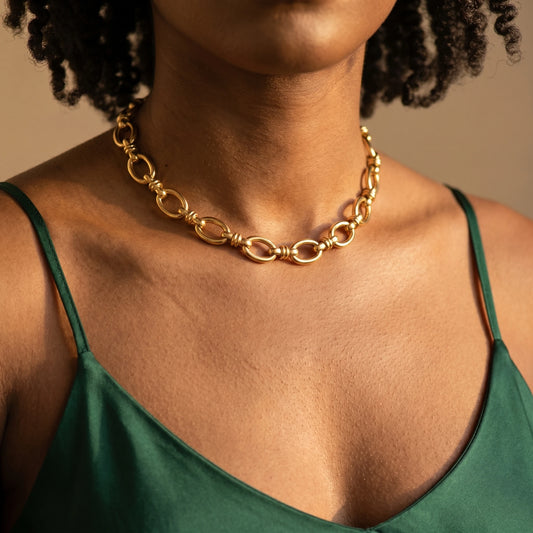 Vintage rolo necklace gold worn close-up at base of throat with emerald silk camisole