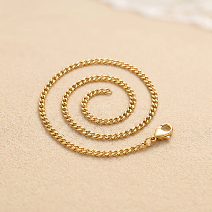 18k gold 4mm curb-link anklet coiled packshot on warm sand