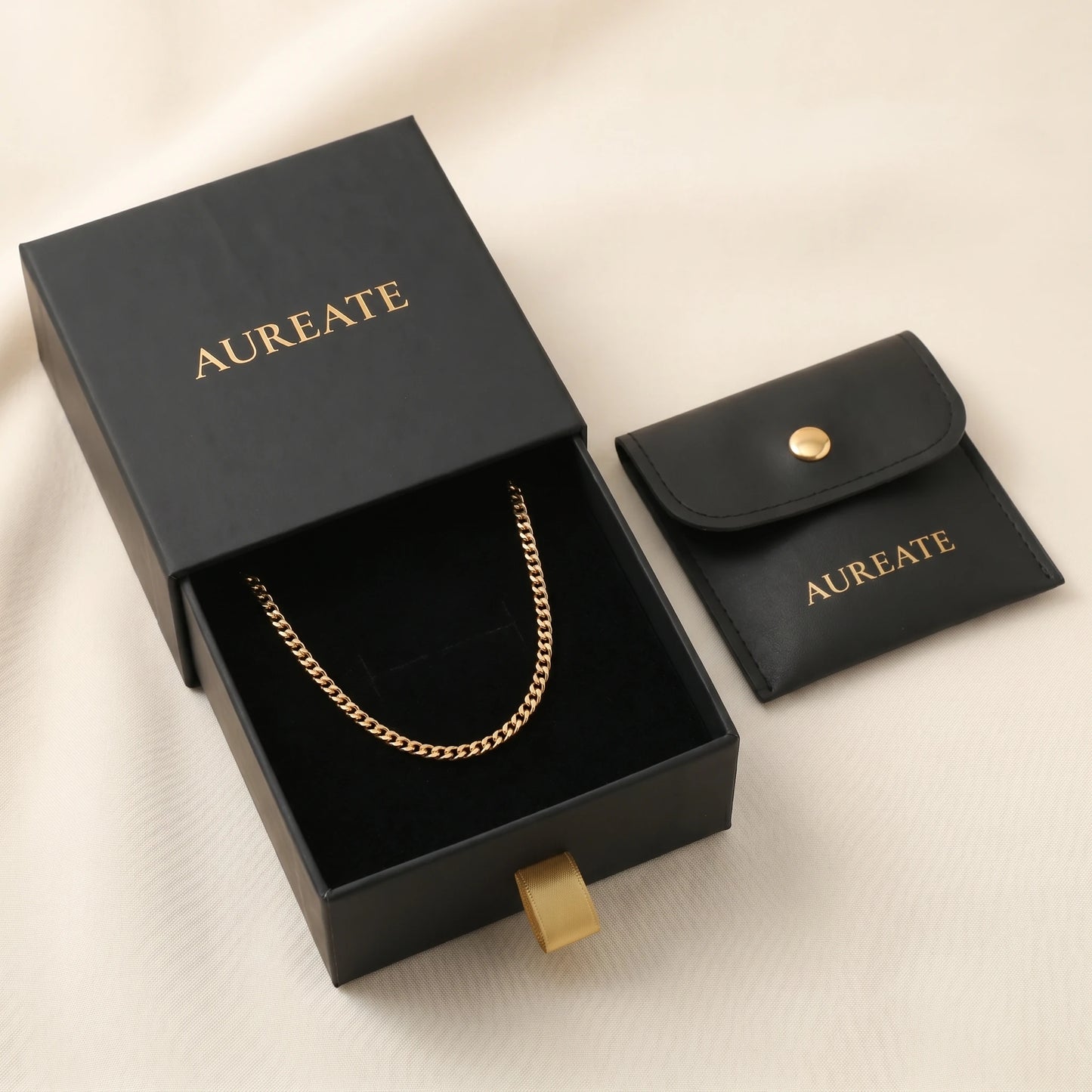 18k gold 4mm curb-link anklet displayed inside open AUREATE gift box, gold logo